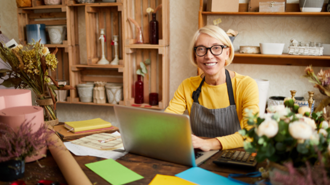 Image of a small business owner working at a laptop in their shop